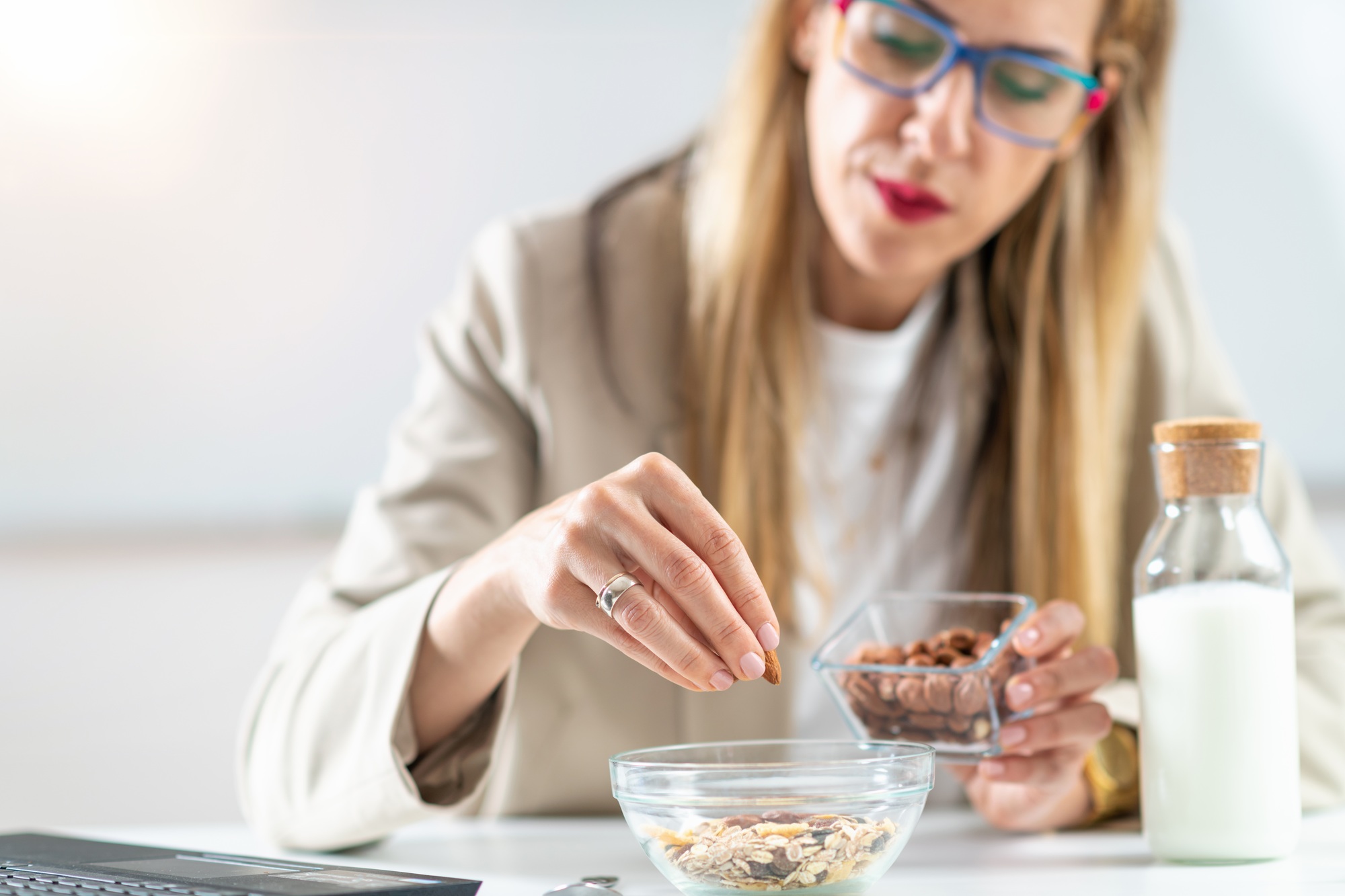 Healthy eating at work as a woman creates a nourishing bowl of muesli,