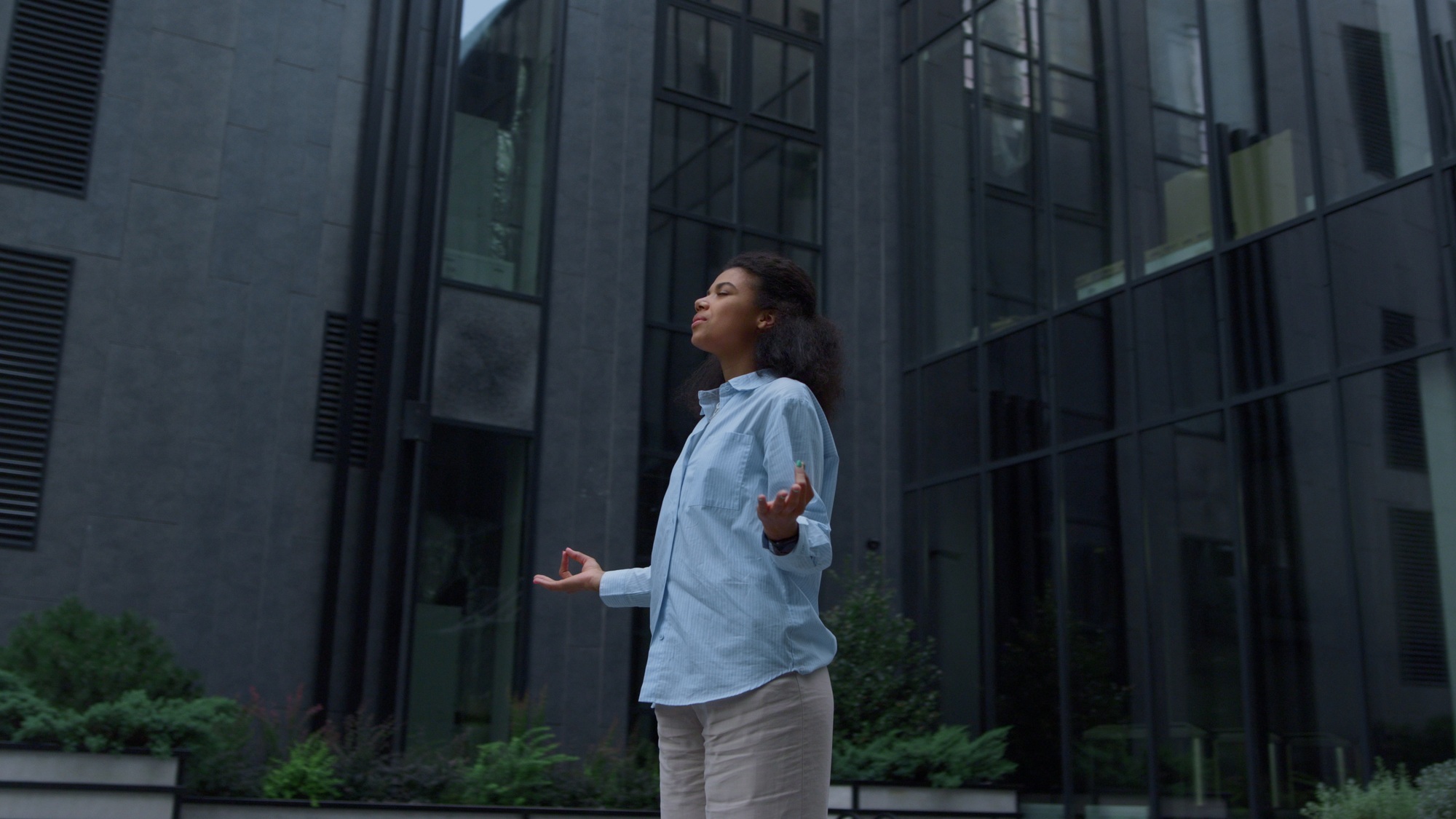 Stressed manager meditating at office building outdoors. Piece of mind concept.