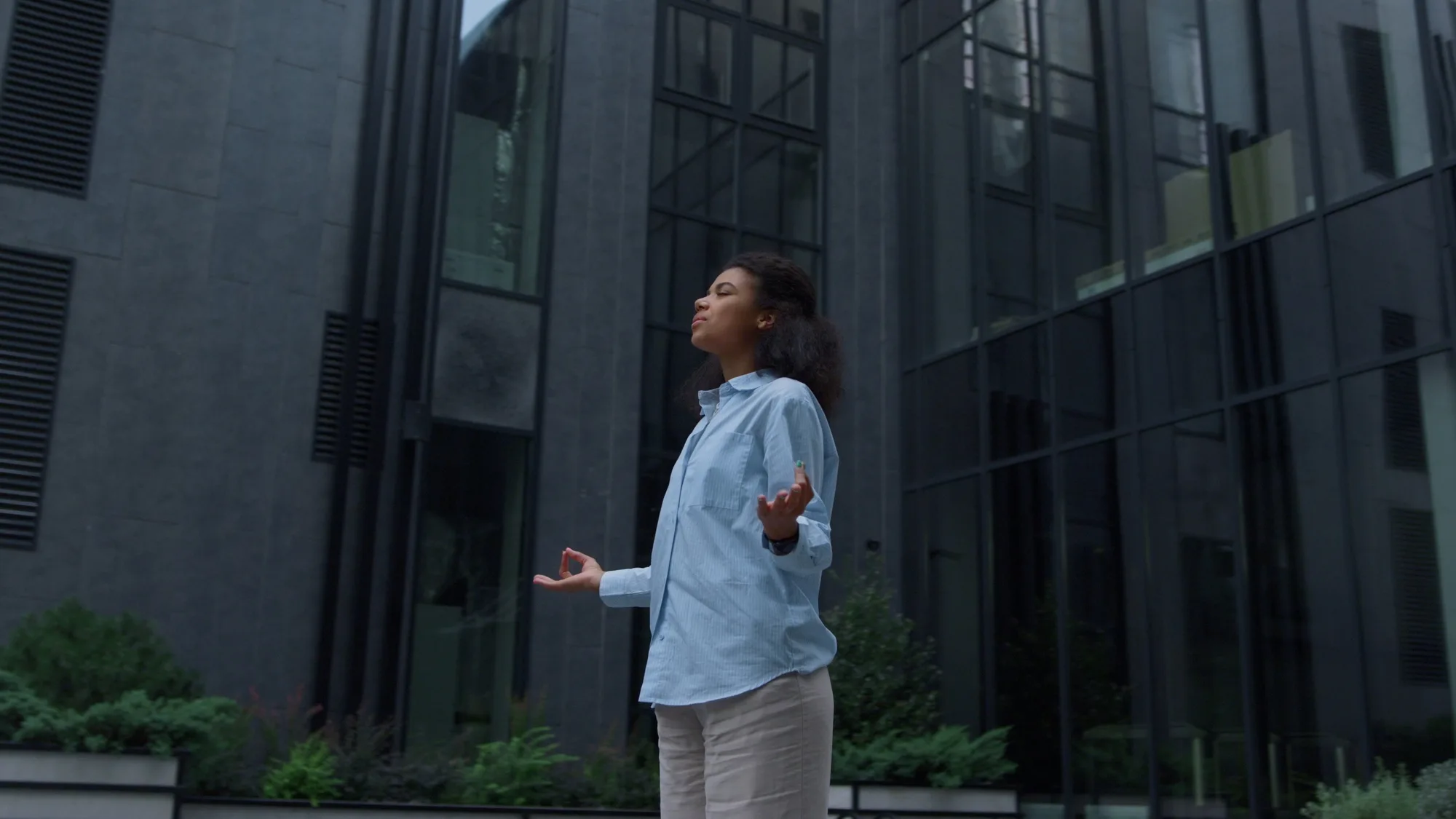 Stressed manager meditating at office building outdoors. Piece of mind concept.